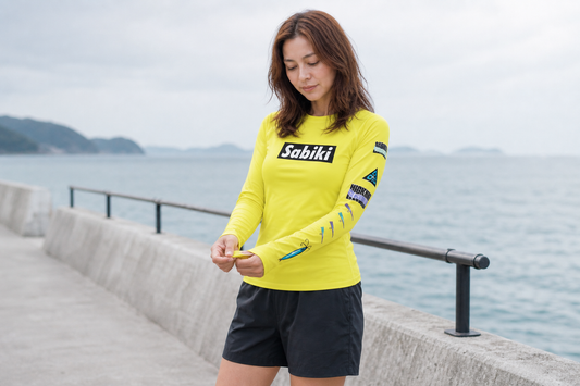 ネオンイエローのSABIKIボックスラッシュガードを着用する女性モデル