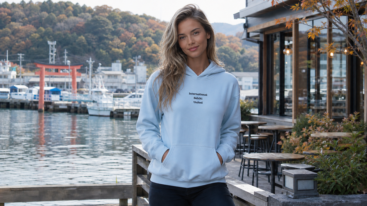 Original SABIKIユニセックスパーカーを着用した女性の海から街へのコーデ