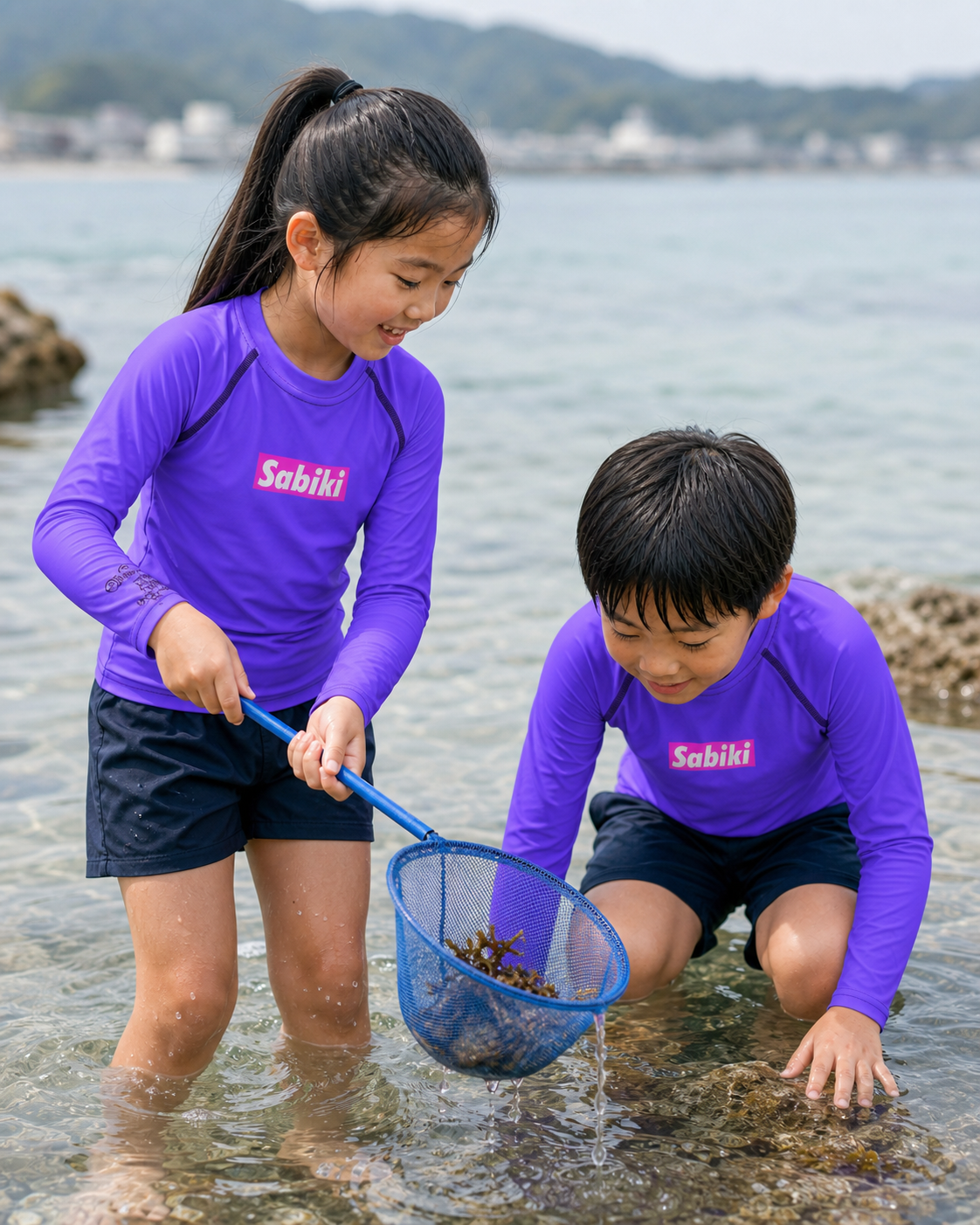 紫のSABIKI BOXキッズラッシュガードを着て磯遊びをする女の子と男の子