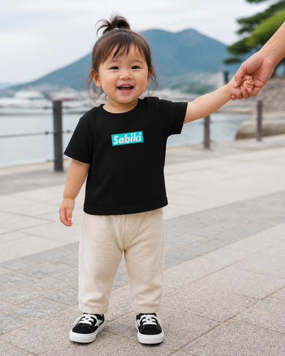 ベビー用SABIKIボックスTシャツ黒を港で着用する女の子